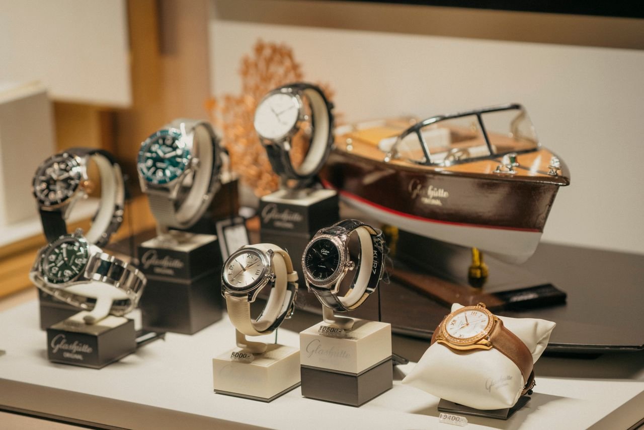 Mastering the First Impression: Your intriguing post title goes here A collection of luxury watches elegantly displayed beside a model boat in a retail environment.
